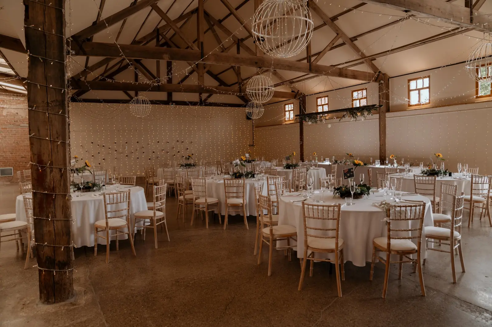 Main Barn set with round tables for the wedding breakfast