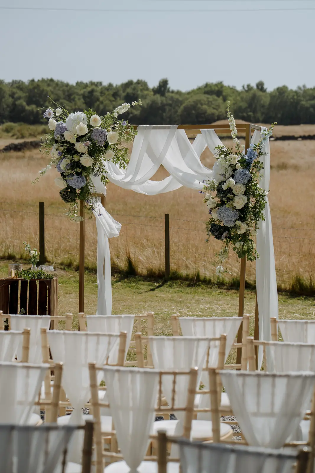 Floral arch set up for an outdoor ceremony overlooking open countryside