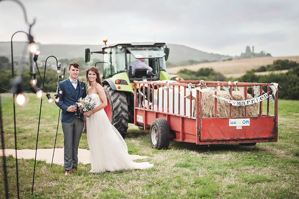 Wedding couple beside a tractor at Purbeck Valley Farm
