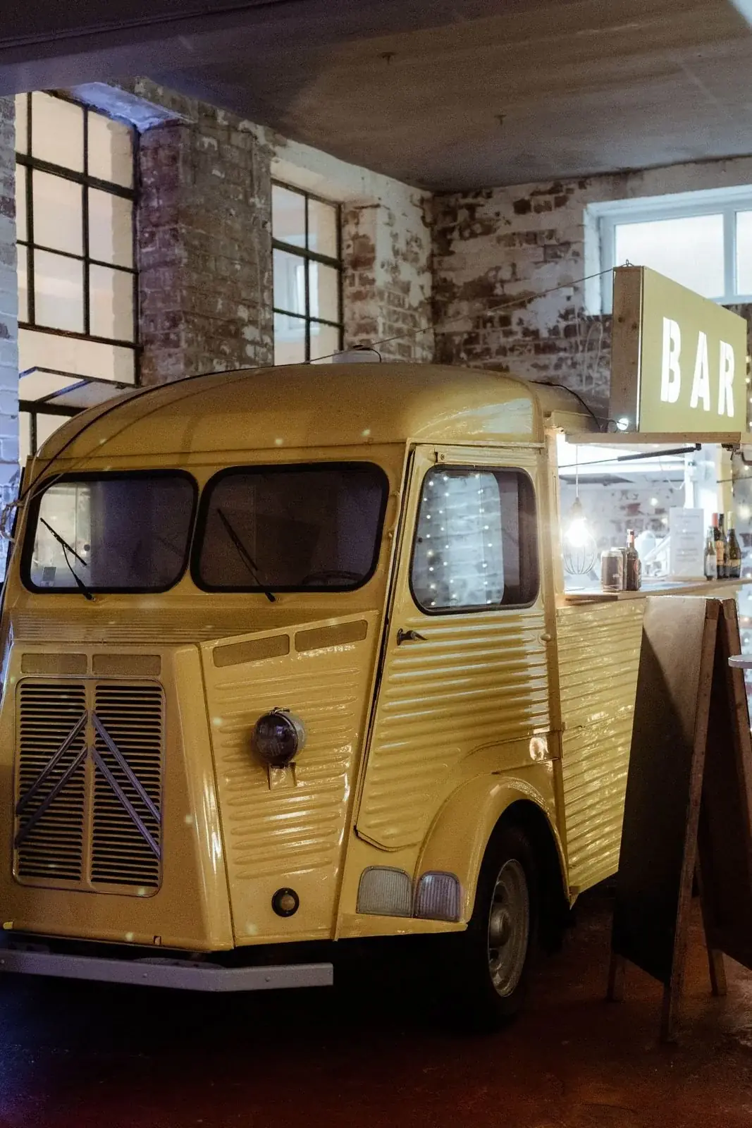 Yellow vintage Citroen H van converted into a bar in the warehouse at the The Hide Wedding and events space, Sheffield.